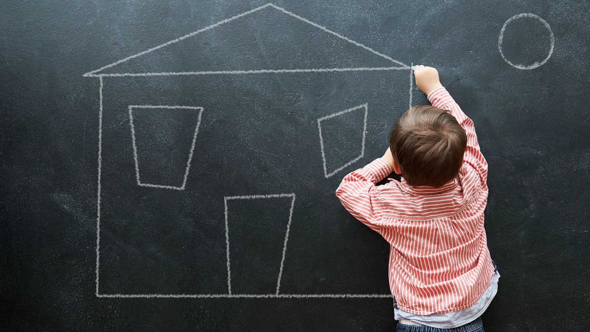 kid drawing house outline with chalk